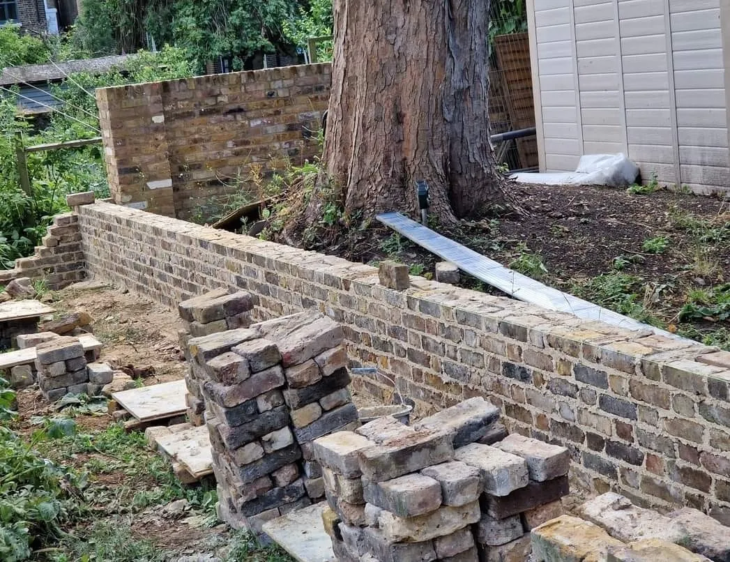 a brick wall is being built around a tree